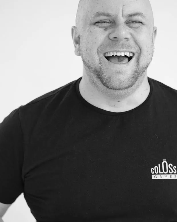 Manuel Prueter laughing, in a Colossi Games t-shirt